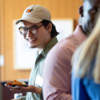 Event guest smiling and holding small plate of food